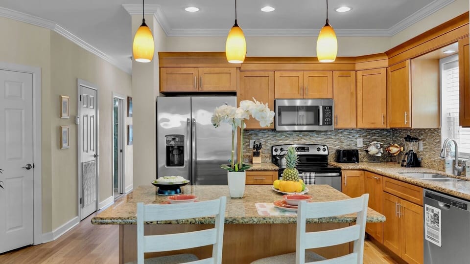 Gather around this bright, fully-equipped kitchen with granite counters, stainless appliances, and a center island perfect for preparing meals and sharing stories with your travel companions.