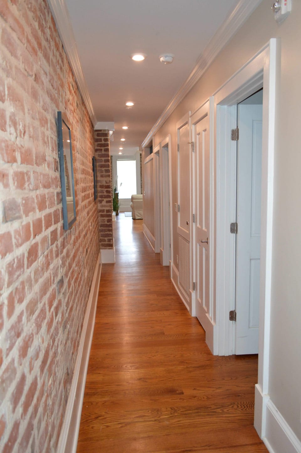 Entry to condo has original exposed brick, tall ceilings and high baseboards, that add to that New Orleans charm