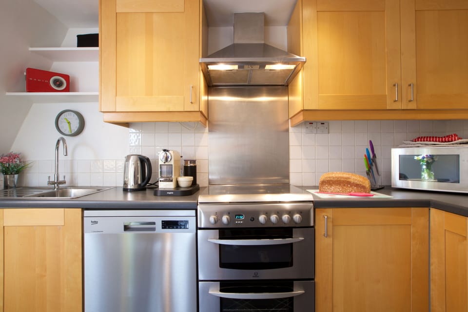 Kitchen with Nespresso machine, dishwasher, cooker, fridge & microwave.