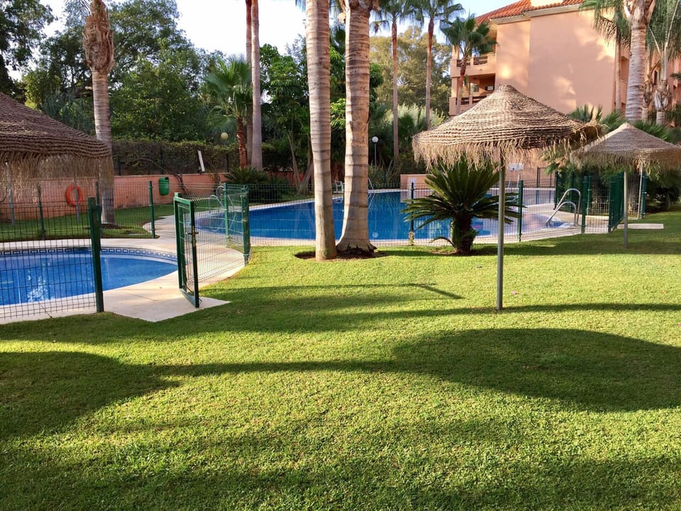 Swimingpool for children and lawn area with umbrellas