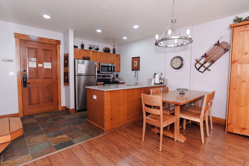 Your fully equipped kitchen and dining area features warm wood cabinetry, modern appliances, and a cozy breakfast nook where you can enjoy meals together.