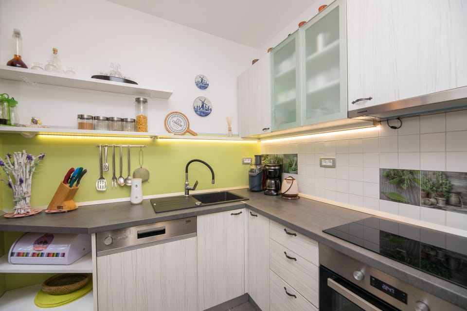Modern, fully equipped kitchen with flat hub, fridge, stove  and dishwasher.