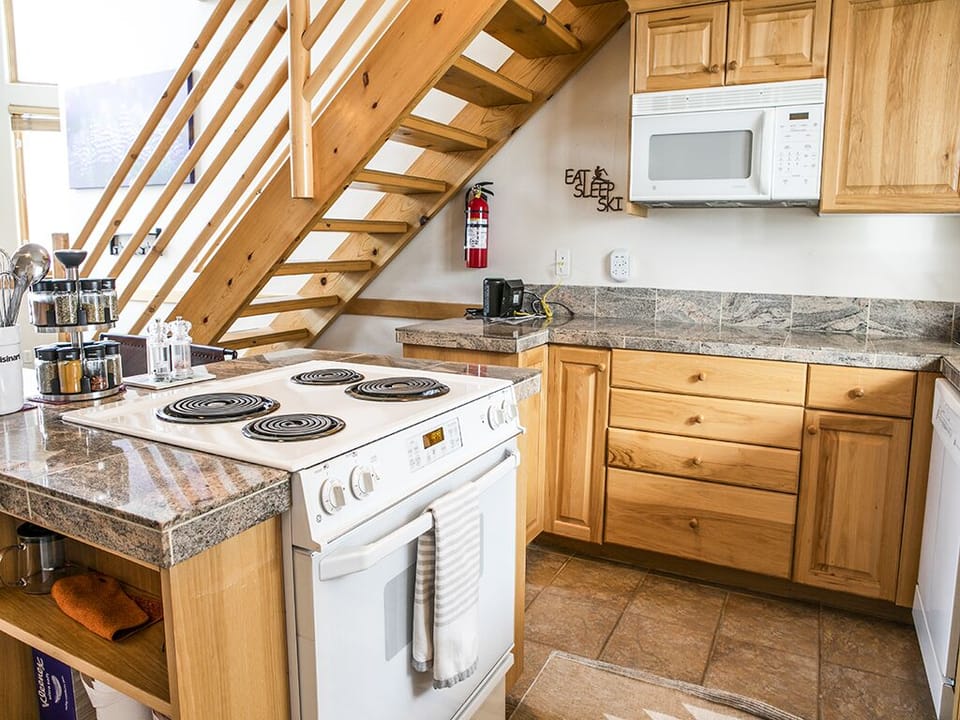 Kitchen with Stove and Microwave - Kitchen with stove and microwave with granite countertops and cabinets and drawers.