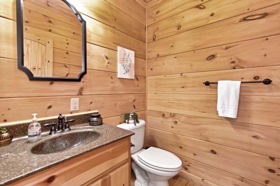 Warm knotty pine walls and stone-look countertops give this bath a cozy mountain feel.
