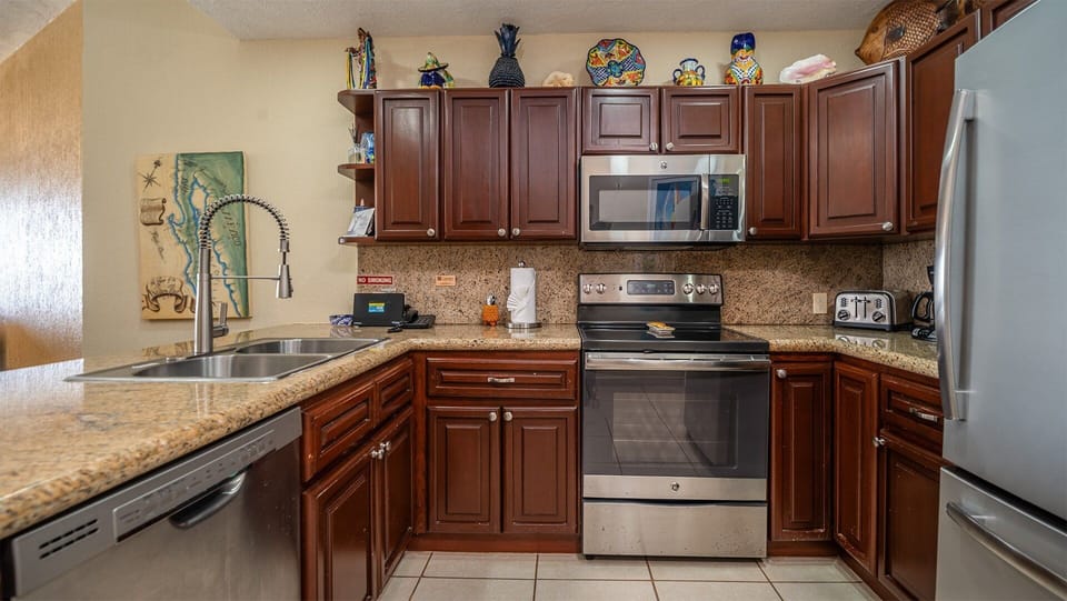 Enjoy cooking in this beautifully designed kitchen, featuring rich dark wood cabinets, modern stainless steel appliances, and charming Mexican décor that adds a warm, local touch to the space.