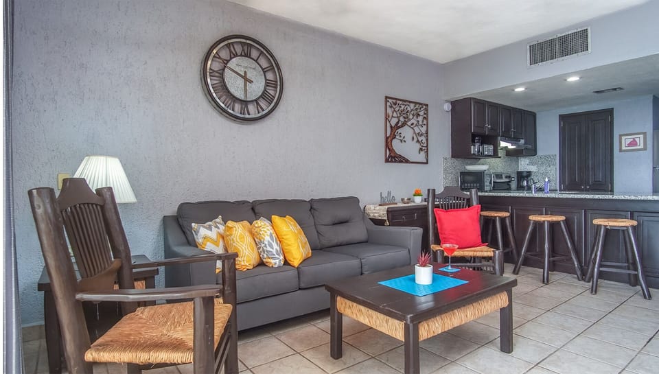 The living room and bar stools at the kitchen counter.