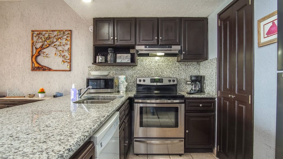 The kitchen is complete, and has a unique custom granite counter and back splash.
