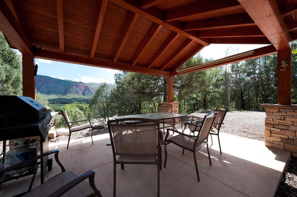 Covered outdoor seating area with dining table, BBQ Grill and awesome views