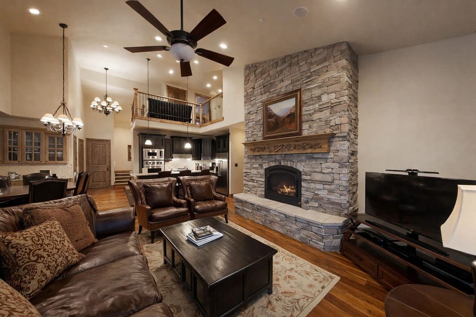 Relax in this cozy mountain retreat featuring a warm stone fireplace, plush seating, and rustic-chic decor. Enjoy a movie on the flat-screen or step onto the balcony for fresh air.