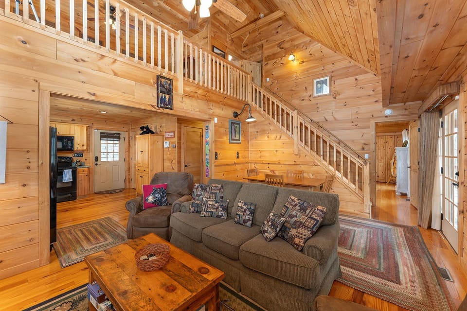 Open-concept living room with cozy seating, gas log fireplace, TV for streaming, and dining for 4
