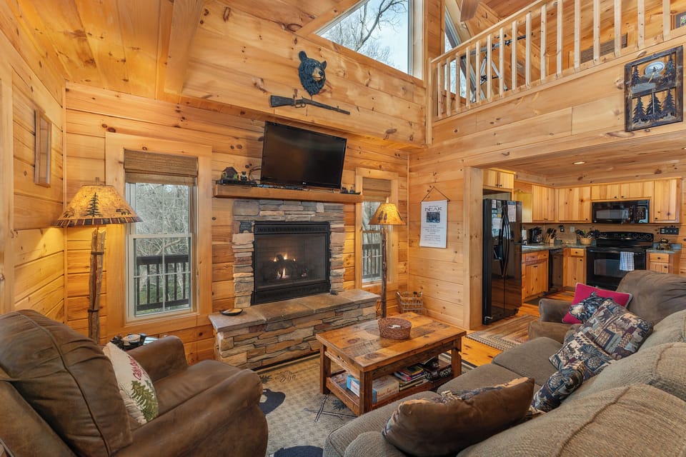 Open-concept living room with cozy seating, gas log fireplace, TV for streaming, and dining for 4