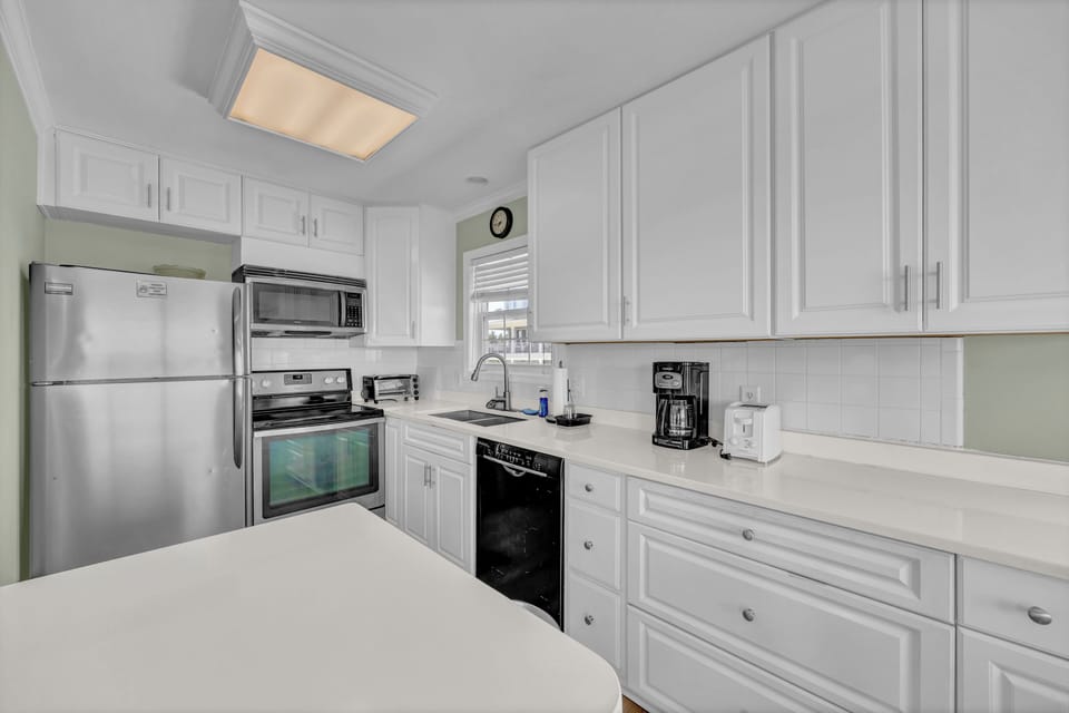 Your fully equipped kitchen features stainless appliances, bright white cabinetry, and ample counter space—perfect for preparing meals during your stay.