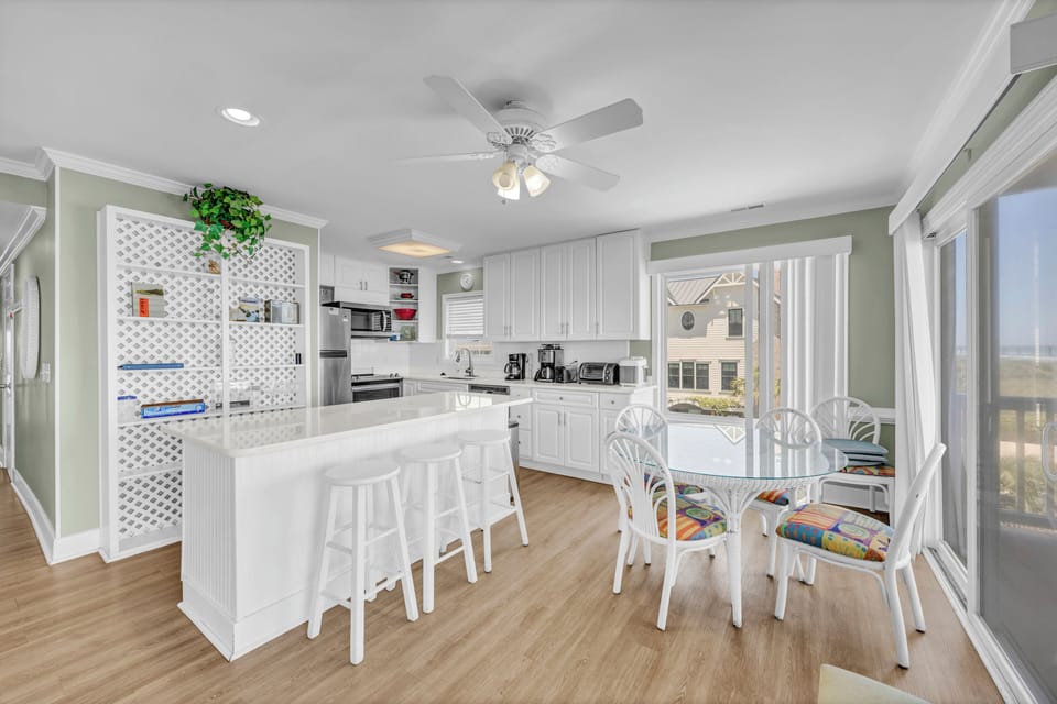 Your bright coastal kitchen awaits, complete with a spacious island for morning coffee, dining nook for family meals, and gorgeous views that invite the outdoors in.
