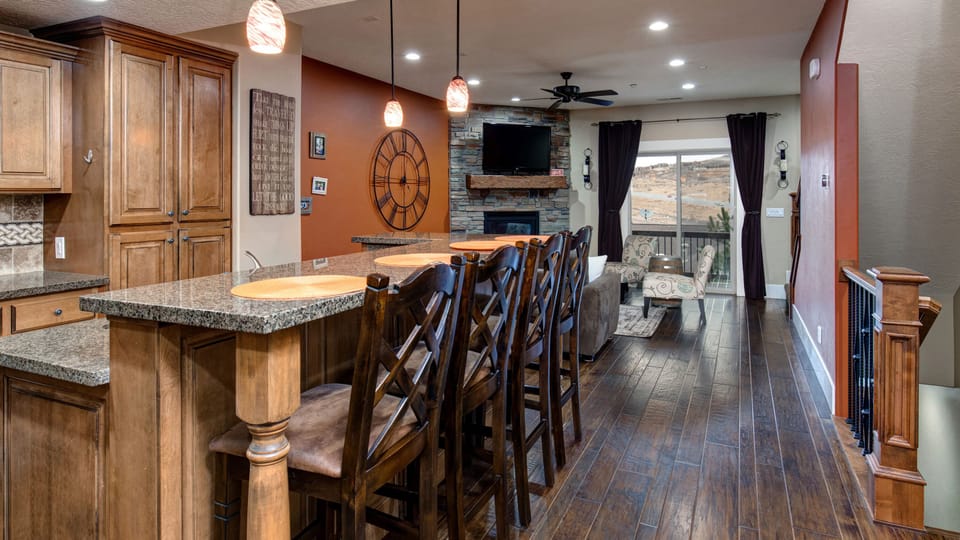 Prepare a gourmet meal in this warm, inviting kitchen featuring rich wood cabinetry and a spacious breakfast bar with seating for four.