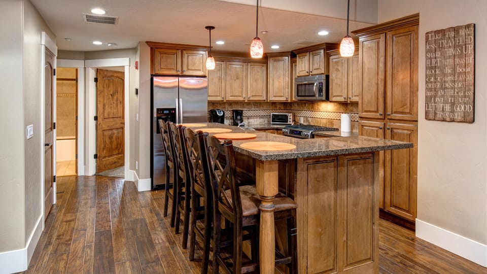 Prepare a gourmet meal in this warm, inviting kitchen featuring rich wood cabinetry and a spacious breakfast bar with seating for four.