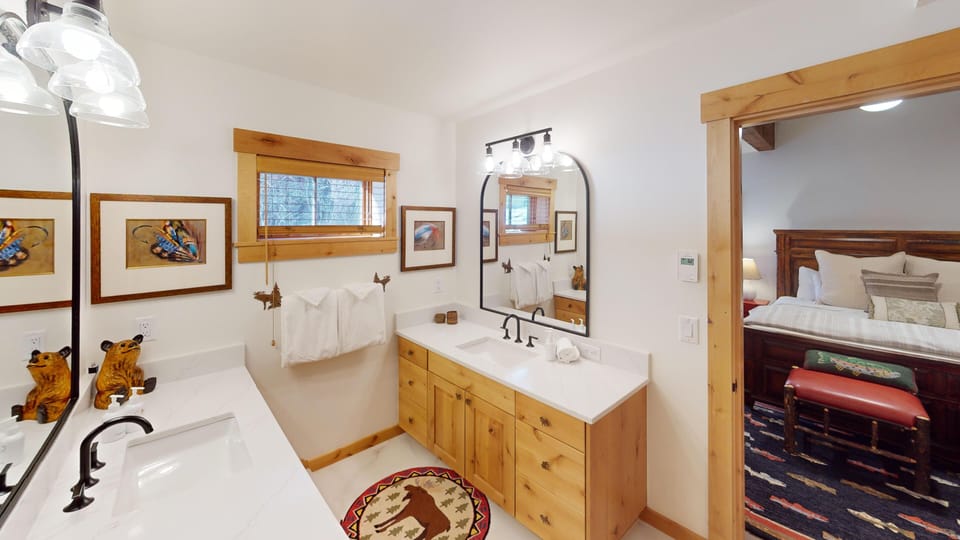 Unwind in your spacious bathroom with dual vanities, soaking tub, and warm wood finishes creating a perfect mountain lodge retreat.
