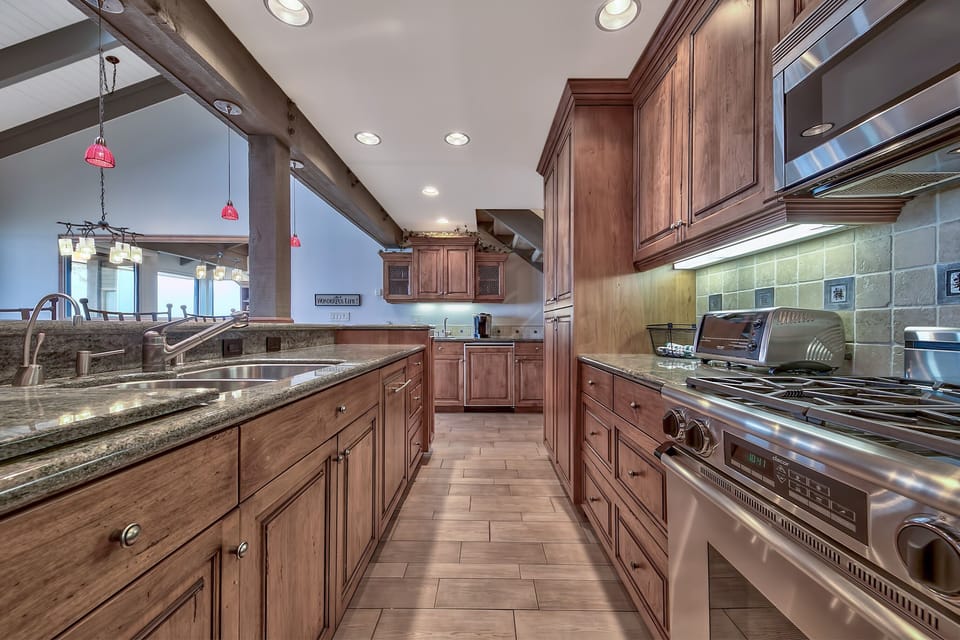 The Kitchen awaits with rich wood cabinetry, granite counters, and professional-grade appliances for memorable cooking experiences.