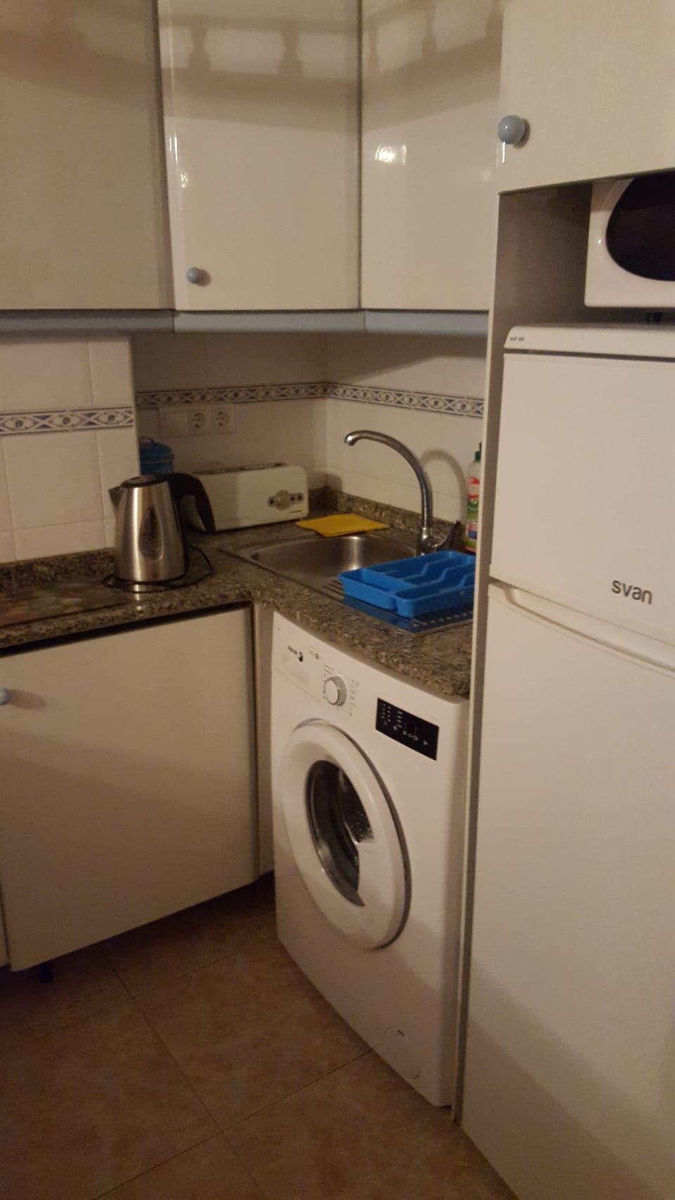 The kitchen with fridge freezer, microwave, toaster and cooker.