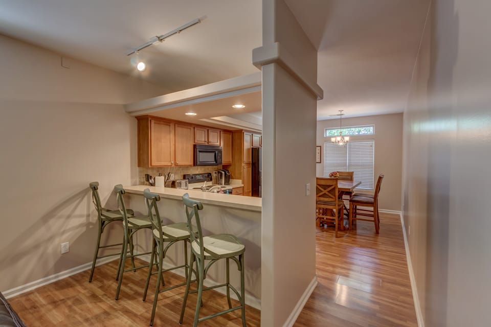 The kitchen bar and barstools provide extra seating when needed. 