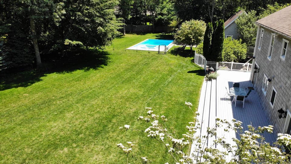 Partial view of sprawling and private backyard leading to heated pool & hot tub