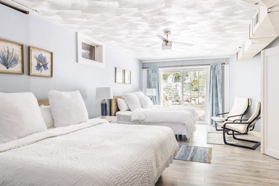 6th bedroom with 2 king beds, en suite bath and sliding glass door to side patio