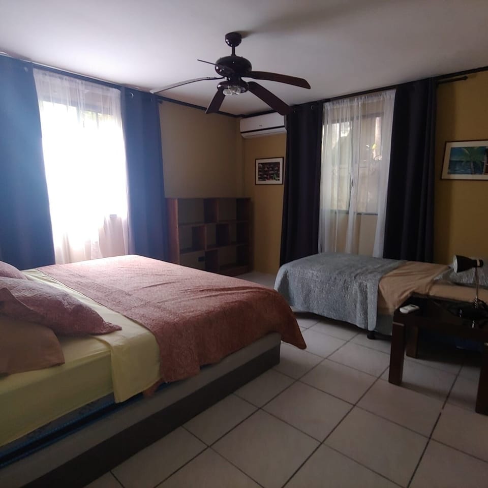 Master bedroom with comfortable king size bed and single bed.
