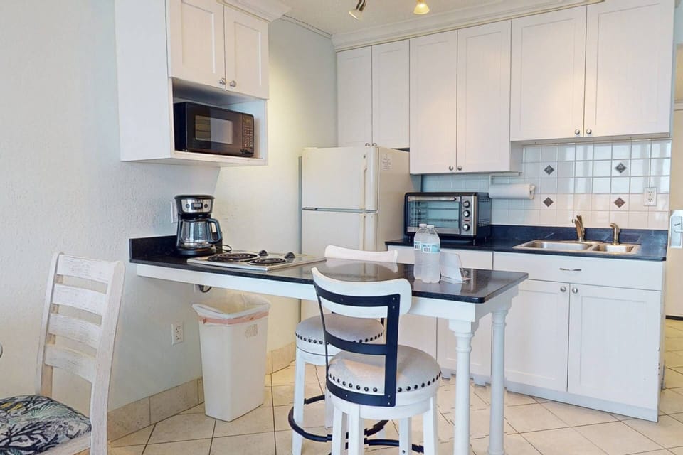 Kitchenette with a Seated Bar-Top and Granite Counters