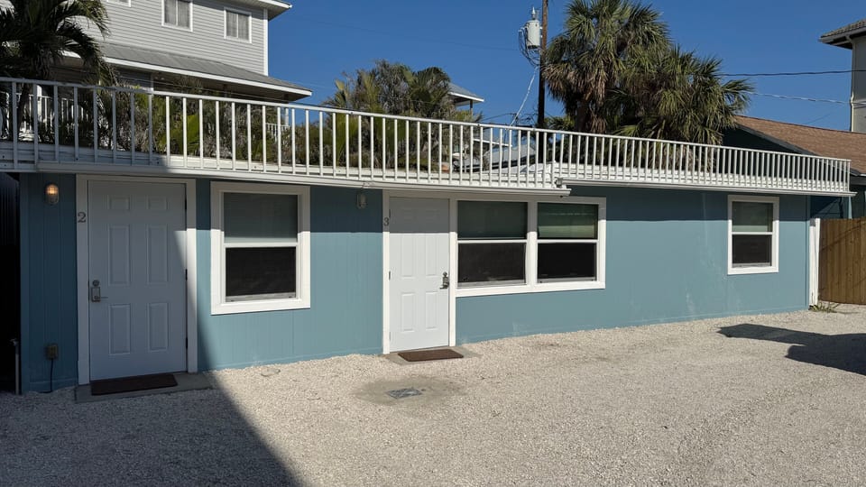 Exterior of the unit showcasing its bright facade just steps from Siesta Key Beach and close to the village.
