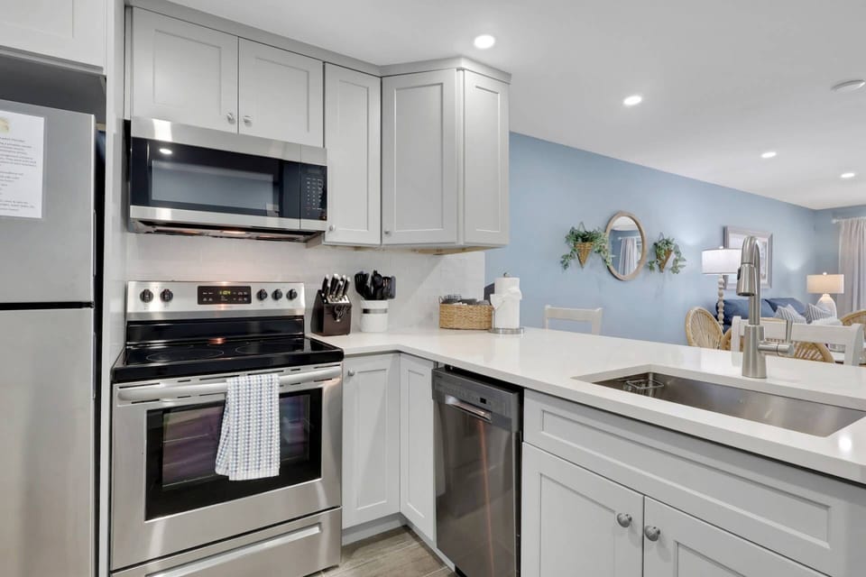 The kitchen offers quartz counters, full size stainless appliances, farmhouse sink and soft close cabinets.