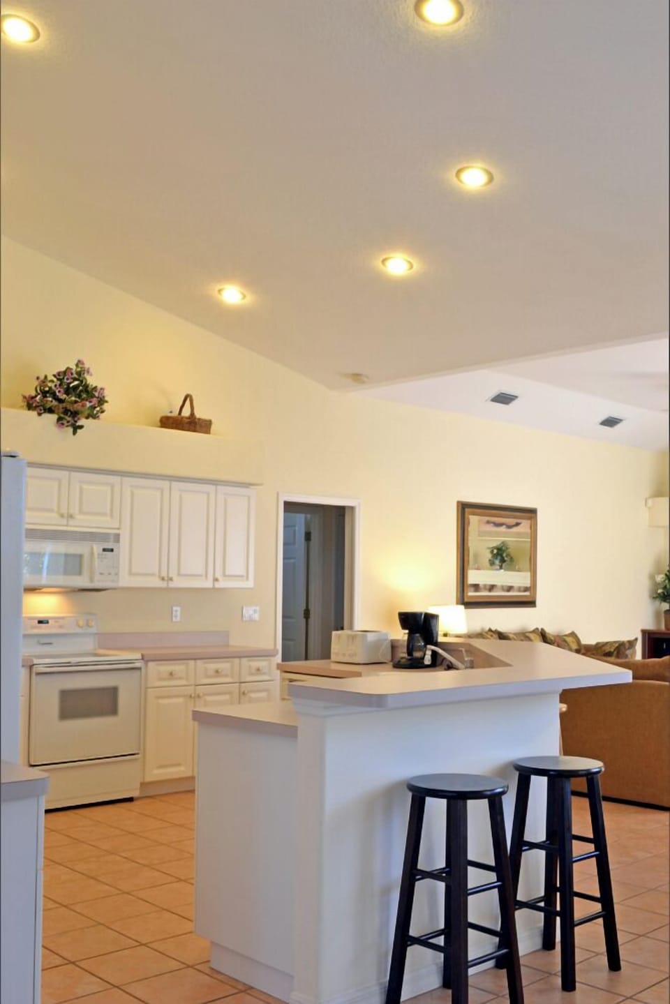 Kitchen with island and breakfast bar, white cabinetry, and stainless appliances