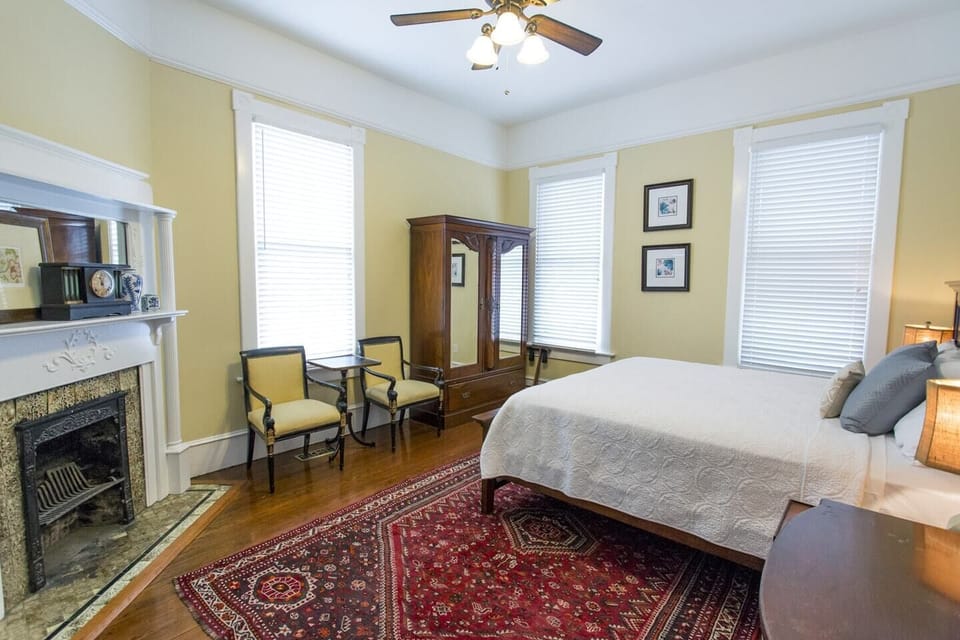 In the primary bedroom, you’ll find another decorative hearth, mirrored armoire and a carved wooden headboard above the king-size bed.