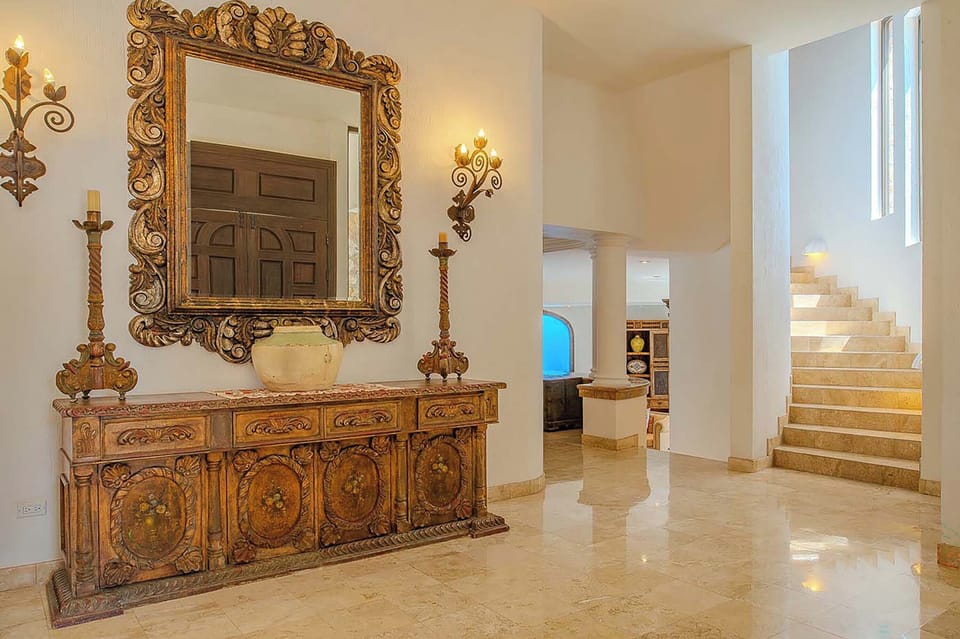 This stunning entry welcomes you with ornate furnishings, glowing sconces, and sun-washed spaces that set the tone for your elegant getaway.