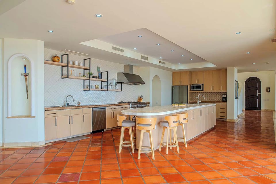 This spacious kitchen features modern appliances, ample counter space, and a large island with seating—perfect for cooking together or enjoying casual meals during your stay.
