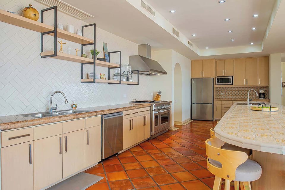 Your spacious kitchen awaits with warm terracotta tile floors, stylish open shelving, and all the modern appliances you need. Cook up a feast on the gas range or gather around the island—your home away from home.