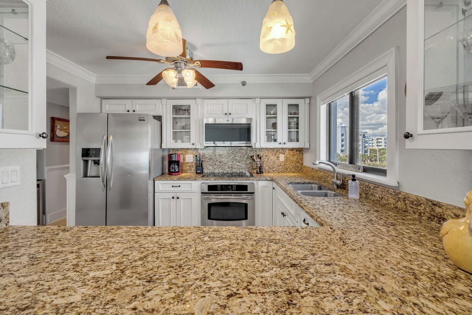 Modern kitchen featuring stainless steel appliances and a picturesque view of the Shorehom by the Sea pool