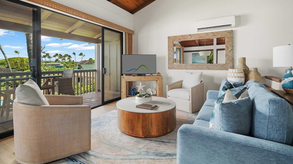 Relax in your spacious living room with coastal-inspired décor, high wooden ceilings, and air conditioning. Step onto your private balcony to enjoy lush tropical views and gentle island breezes.