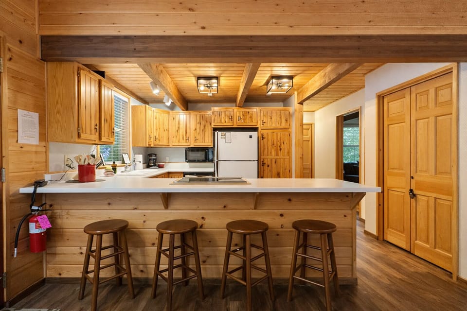 Your rustic kitchen welcomes with warm wood and a spacious breakfast bar for casual meals and coffee conversations.