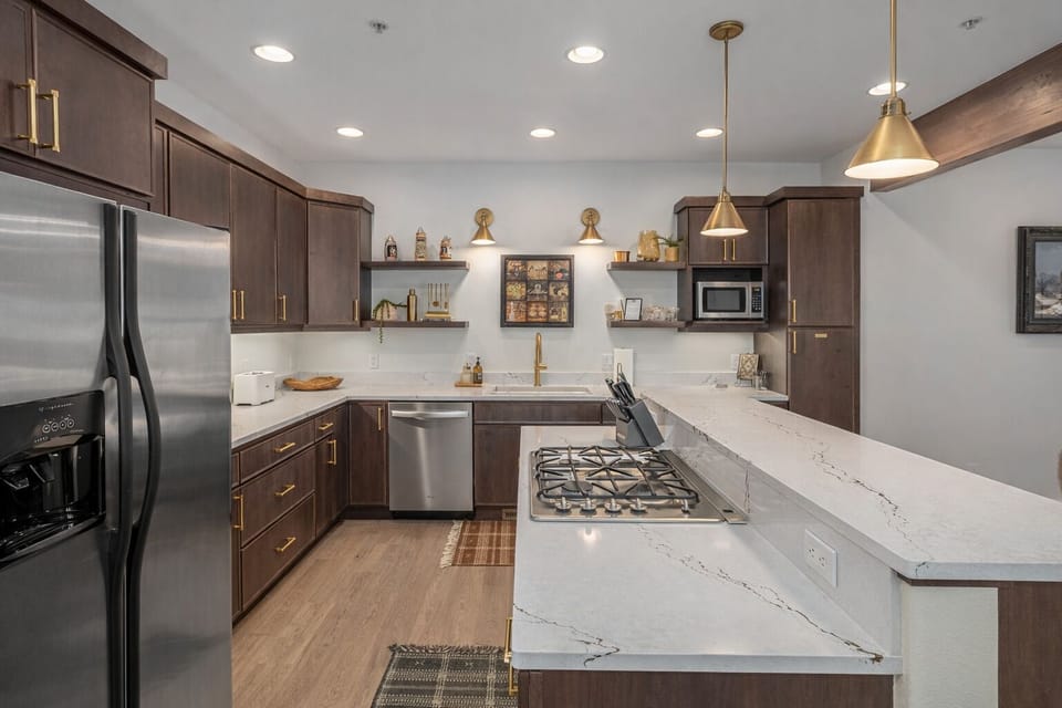 Your fully equipped kitchen features elegant marble countertops, stainless steel appliances, and warm brass fixtures for memorable meal preparation.