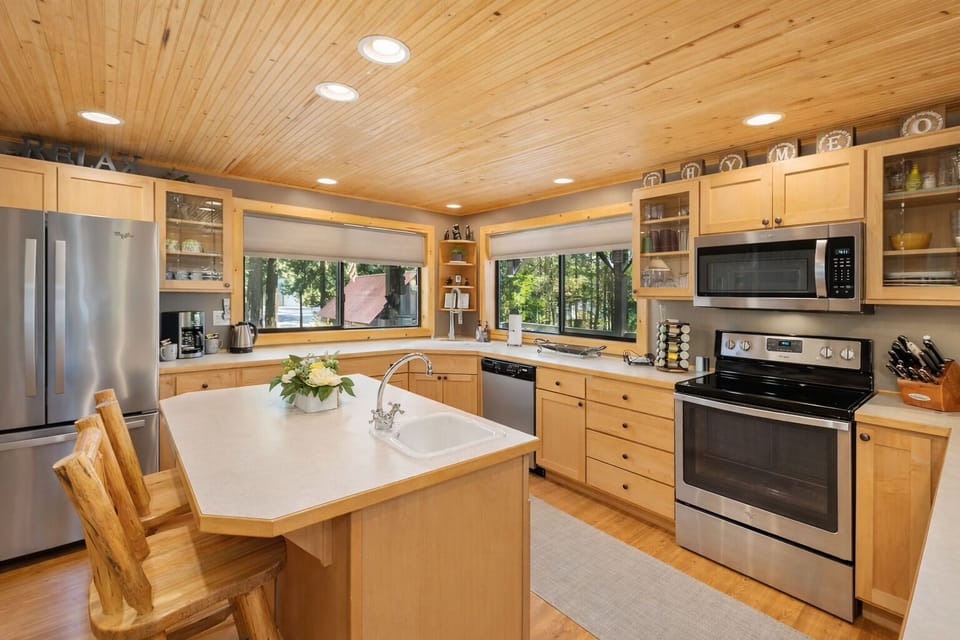 Your fully equipped kitchen features warm wood cabinetry, modern appliances, and a charming island perfect for cooking memorable meals.