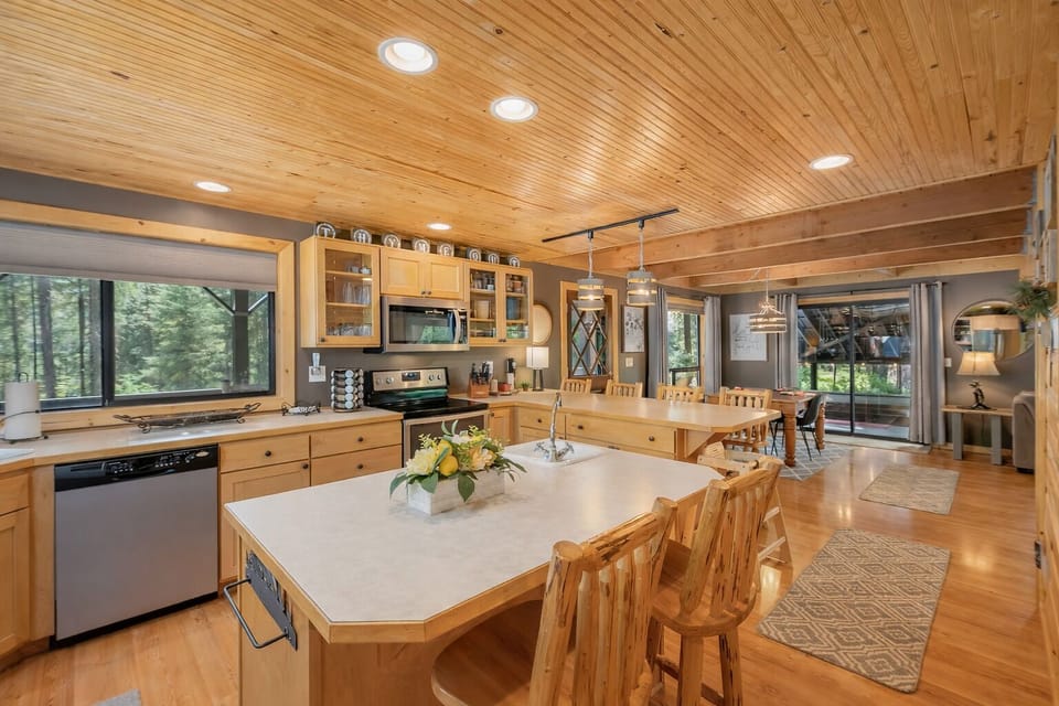 Your gourmet kitchen features natural wood throughout, spacious island seating, and forest views through every window.