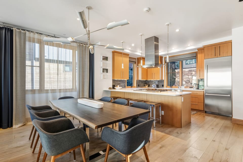 Spacious open-concept living, dining, and kitchen area with elegant table seating for eight, perfect for entertaining and gatherings.