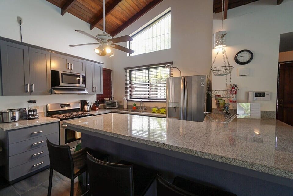 Modern kitchen with granite countertops, side by side refrigerator, dishwasher and gas stove