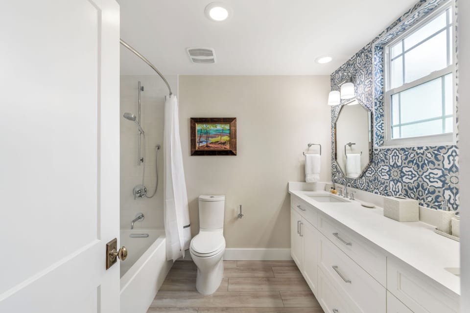 Bedroom #4 shares this hall bathroom equipped with a dual vanity and shower bath.