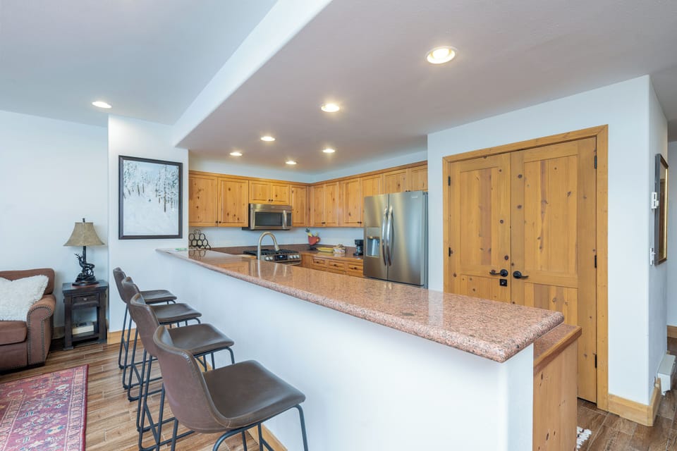Gather around your spacious kitchen island where warm wood cabinets and granite counters create the perfect spot for morning coffee or evening conversations.