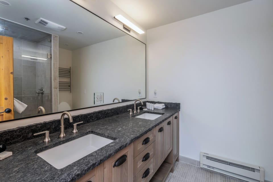 Unwind in your modern bathroom with dual vanities, granite countertops, and a spacious glass shower where relaxation begins.