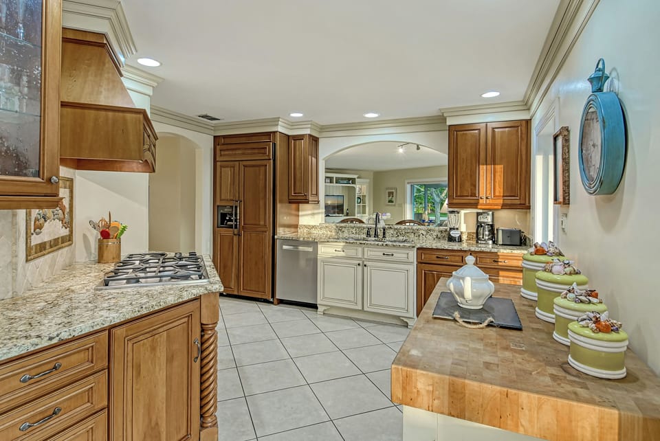 The kitchen exudes warmth and character with rich wood cabinetry and polished granite countertops that balance beauty and function.