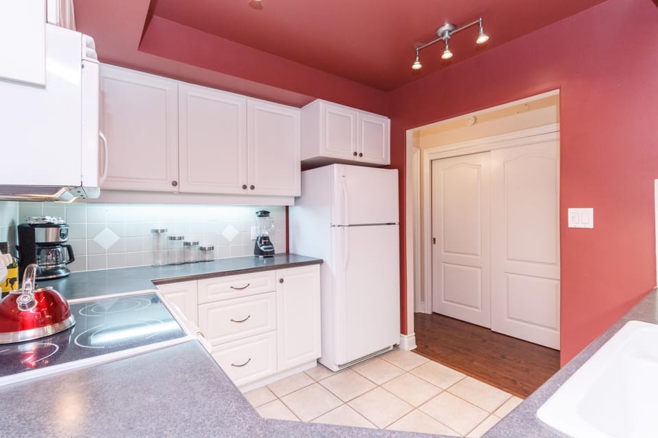 Another angle of the fully equipped kitchen, displaying clean countertop prep spaces and handy under-cabinet lighting.