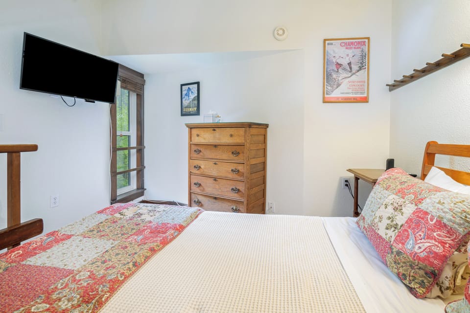 Sink into a cozy bed with cheerful quilted accents, enjoy your favorite shows on the wall-mounted TV, and store your belongings in the charming wooden dresser.