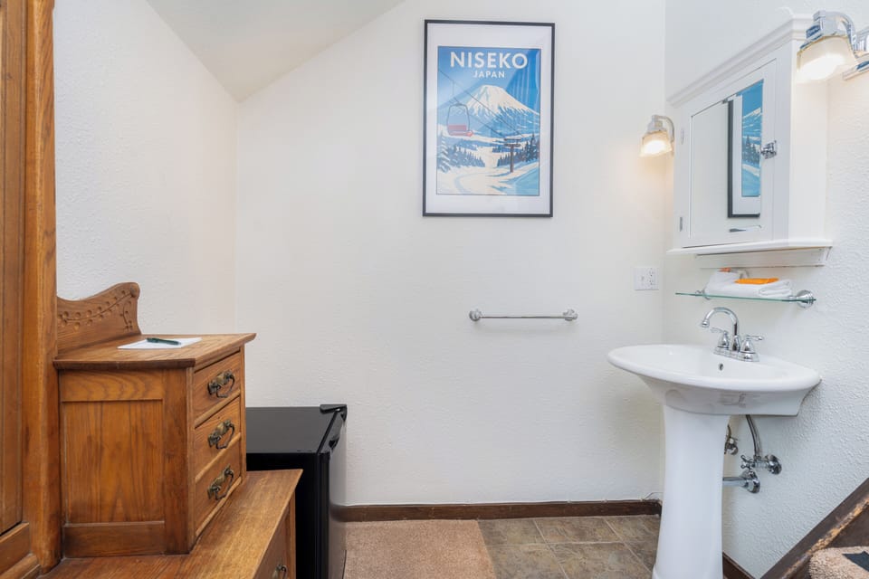 Refresh in your private bathroom with its clean lines and charming vintage decor. You'll appreciate the thoughtful touches like the pedestal sink and vintage poster.