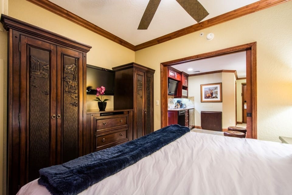 The second Primary Suite separated by pocket doors from the living area, features a king size bed with luxury linens & bedding, large armoire and dres